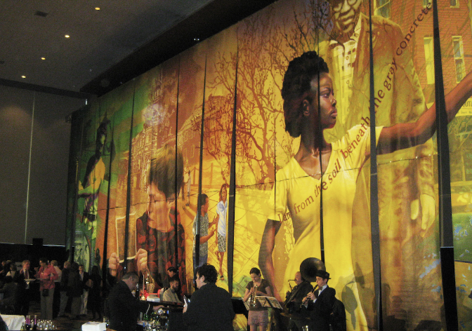 A large, colorful mural of several people outdoors on a wall inside a building